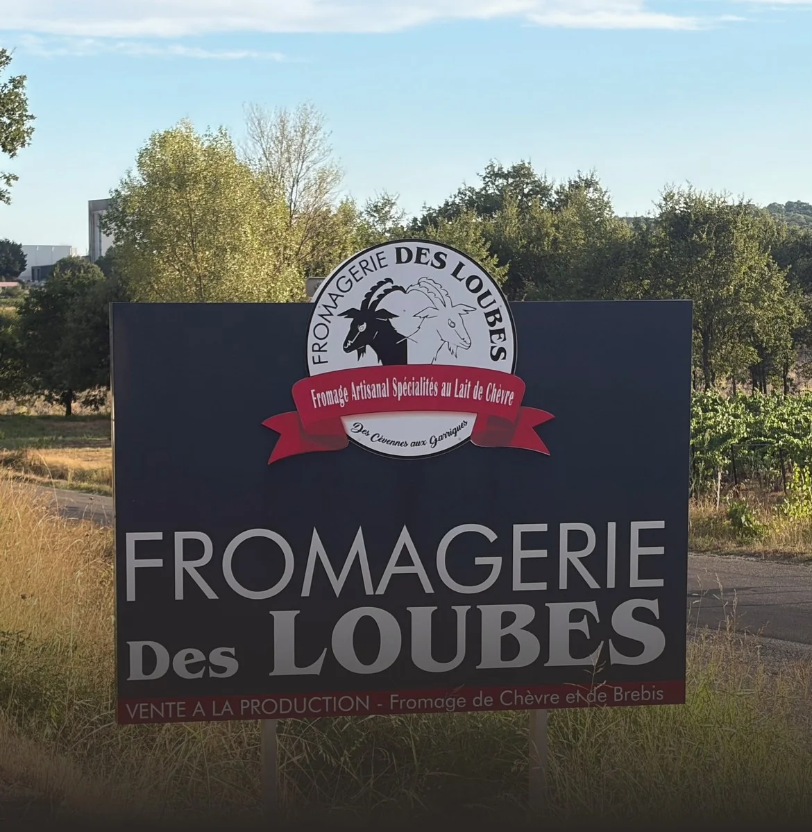 Le panneau d'entrée de la Fromagerie des Loubes, au bord de la route